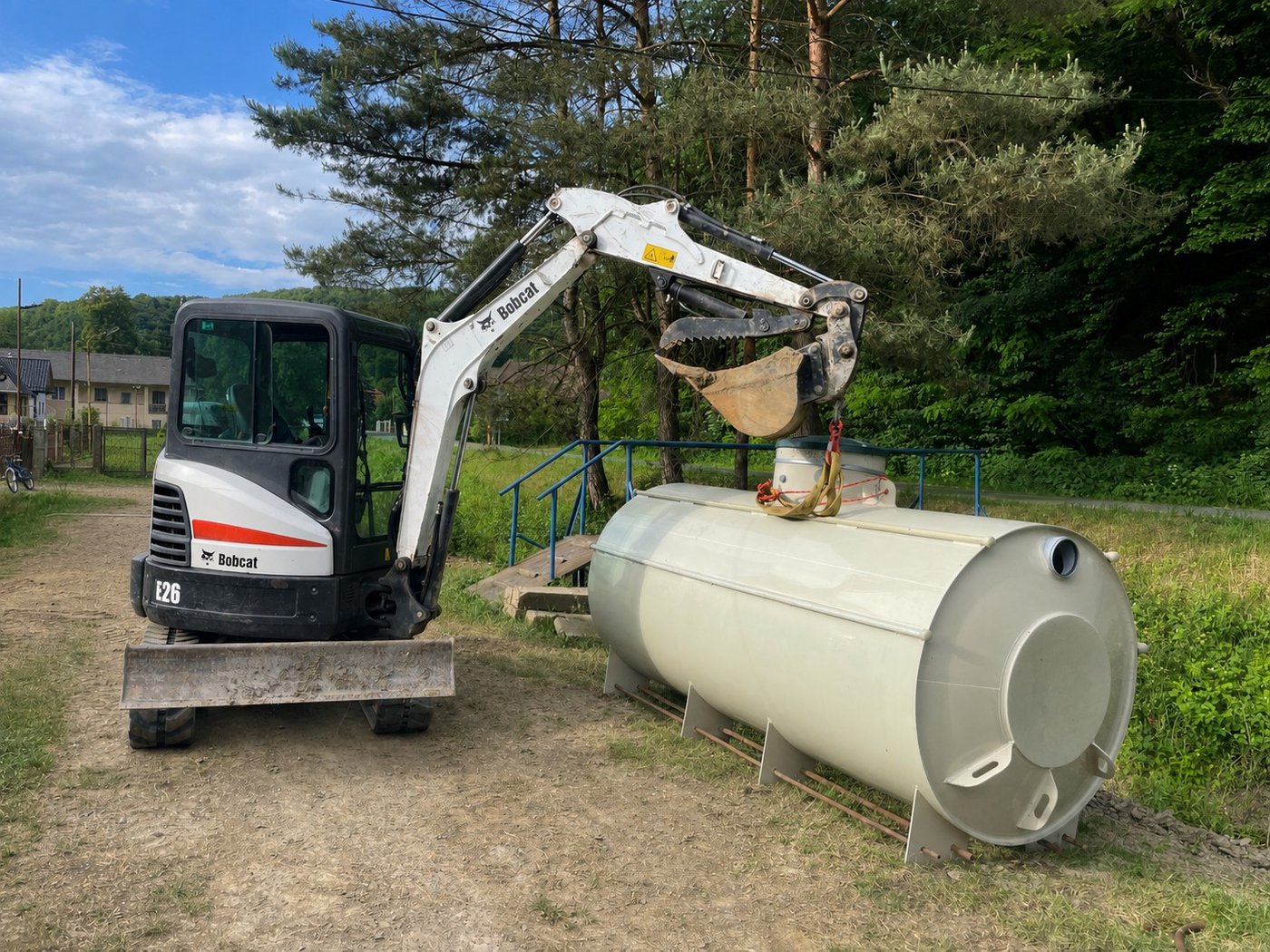 Minibager Bobcat E26 pri manipulácii s nádržou
